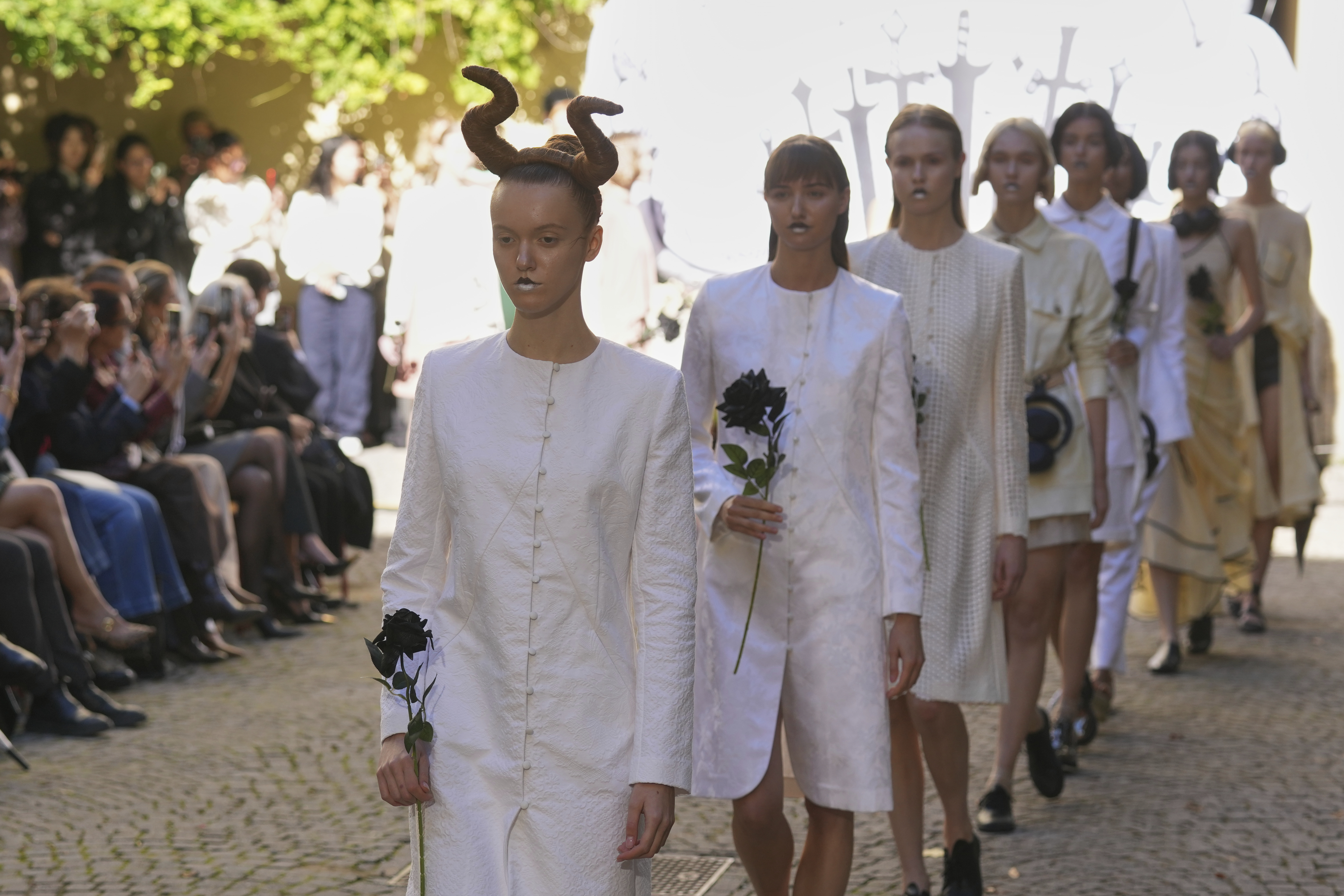 Models wear creations as part of the Francesca Liberatore SpringSummer 2026 collection as they hold black roses, in Milan, Italy, Sunday, Sept. 28, 2025. (AP)